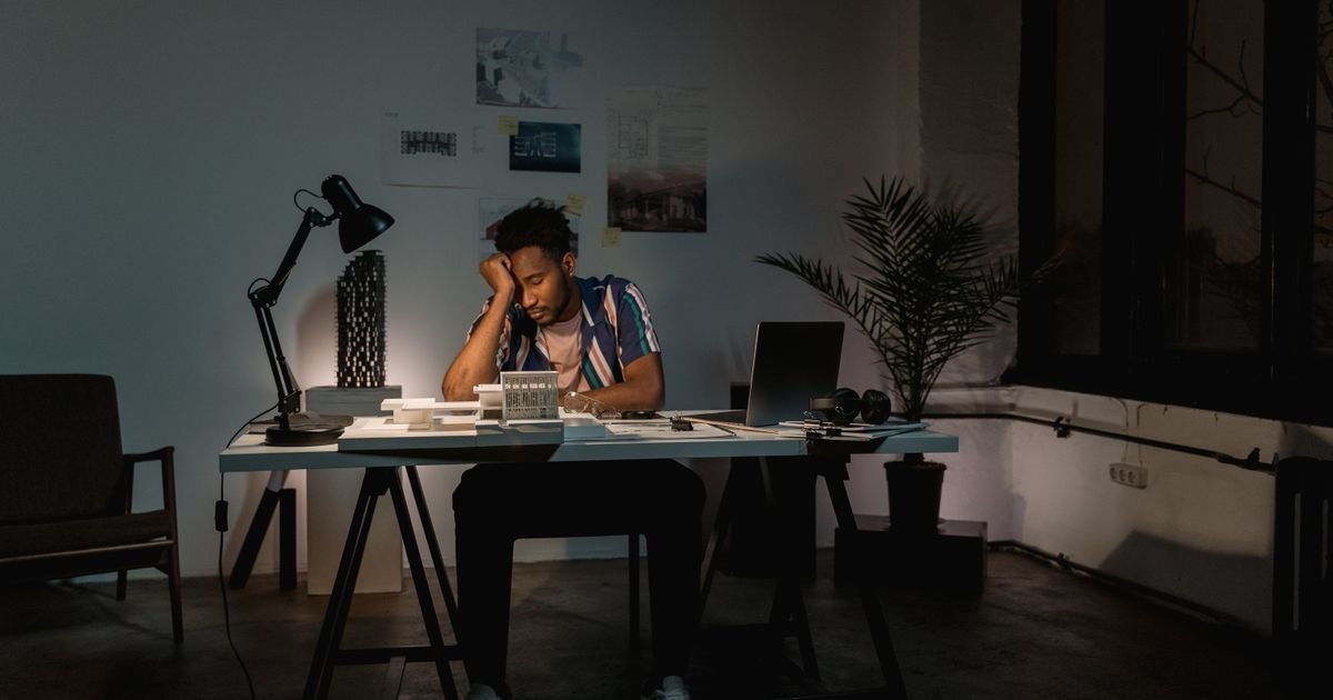 Trabalhador cansado fazendo horas extras à noite no escritório